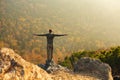 happy man standing at the top of the mountain. Landscape view of misty autumn mountain hills and man silhouette