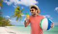 Happy man in straw hat with juice on beach Royalty Free Stock Photo