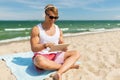 Happy man with tablet pc and headphones on beach Royalty Free Stock Photo