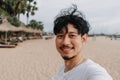 Happy man take selfie with palm tree on the beach. Summer travel concept. Royalty Free Stock Photo