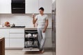 happy man taking out clean glass from dishwasher Royalty Free Stock Photo