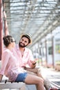Happy man talking to woman while sitting on bench under shade Royalty Free Stock Photo