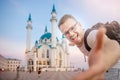 Happy man tourist with backpack takes selfie photo on background of Kul Sharif Mosque Kazan Kremlin. Concept Travel Royalty Free Stock Photo