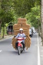Happy man is transporting goods on a motorbike on a street in Ubud, island Bali, Indonesia, close up