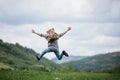 Happy Man traveler jumping with backpack in mountains active summer vacations, travel concept Royalty Free Stock Photo
