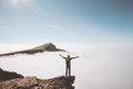 Happy man traveler standing alone on cliff edge mountain over clouds