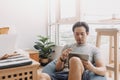 Happy man use tablet for work on bean bag in the living room of the house. Royalty Free Stock Photo