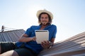 Happy man using digital tablet on hammock at beach Royalty Free Stock Photo