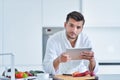 Happy man using digital tablet in kitchen at home Royalty Free Stock Photo