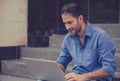 Happy man using his laptop computer outdoors smiling Royalty Free Stock Photo