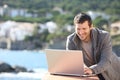 Happy man using a laptop in a balcony in winter Royalty Free Stock Photo