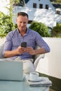 Happy man using mobile phone while sitting in cafe Royalty Free Stock Photo