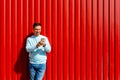 Man using smar phone on the background of red wall