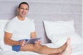 Happy man using tablet pc on bed Royalty Free Stock Photo