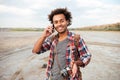 Happy man with vintage photo camera talking on mobile phone Royalty Free Stock Photo