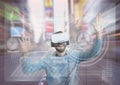 Happy man in VR headset touching interfaces against city background Royalty Free Stock Photo