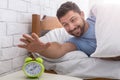 Happy man waking up and stopping alarm clock Royalty Free Stock Photo