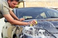 Happy man washing car with a sponge and foam Royalty Free Stock Photo