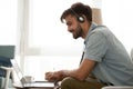 Happy man wearing headset study online on laptop making notes Royalty Free Stock Photo