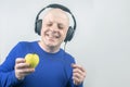 Happy man wearing portable full-size headphones listens to music using an apple player Royalty Free Stock Photo