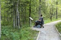 Man on a wheelchair in a forest.