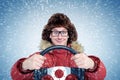 Happy Man in winter clothes with a steering wheel, snow blizzard. Concept car driver Royalty Free Stock Photo