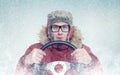 Happy man in winter clothes with a steering wheel, snow blizzard. Concept car driver Royalty Free Stock Photo