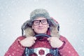 Happy man in winter clothes with a steering wheel, snow blizzard. Concept car driver Royalty Free Stock Photo