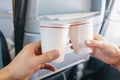 Man and a woman clink paper cups in the interior of an airplane during a vacation flight. Catering and wine tasting