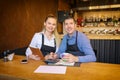 Happy man and woman going through paperwork together in their restaurant, discussing finance calculating bills. Royalty Free Stock Photo