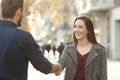 Happy man and woman handshaking in a city street