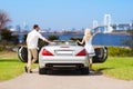 Happy man and woman near cabriolet car in tokyo Royalty Free Stock Photo