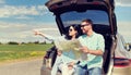 Happy man and woman with road map at hatchback car Royalty Free Stock Photo