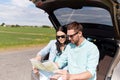 Happy man and woman with road map at hatchback car Royalty Free Stock Photo