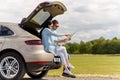 Happy man and woman with road map at hatchback car Royalty Free Stock Photo