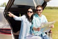 Happy man and woman with road map at hatchback car Royalty Free Stock Photo