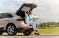 Happy man and woman with road map at hatchback car Royalty Free Stock Photo