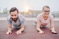 Couple sportsmen training together outdoor, plank pose on elbows Royalty Free Stock Photo