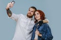 Bionic man taking selfie with a woman over blue background