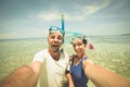 Happy man and woman taking selfie wearing snorkeling mask in tropical caribbean sea. Adult mid age traveling couple, real people Royalty Free Stock Photo