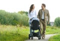 Happy man and woman walking with baby pram outdoors Royalty Free Stock Photo