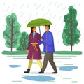 Happy man and woman are walking in city park under an umbrella, go on the background of green trees Royalty Free Stock Photo