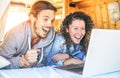 Happy man and woman watching surprised on their computer - Travel couple using laptop during their journey on a vintage minivan Royalty Free Stock Photo