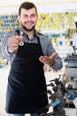 Happy man worker displaying result of his key making in workshop Royalty Free Stock Photo