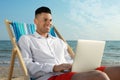 Happy man working with laptop on beach. Business Royalty Free Stock Photo