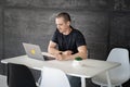 Happy man working on laptop in library or coworking office space Royalty Free Stock Photo