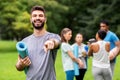 Happy man with yoga mat pointing finger to camera Royalty Free Stock Photo