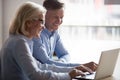 Happy manager and client having conversation at meeting with laptop