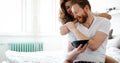 Happy married couple being romantic in bed sharing cereal