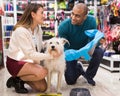 Happy married couple with dog in pet shop
